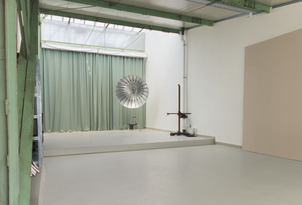 Studio space with green curtain, para umbrella and camera stand